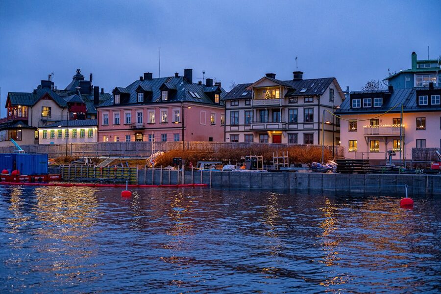 Waterfront houses reflecting on water at dusk in Stockholm Sweden