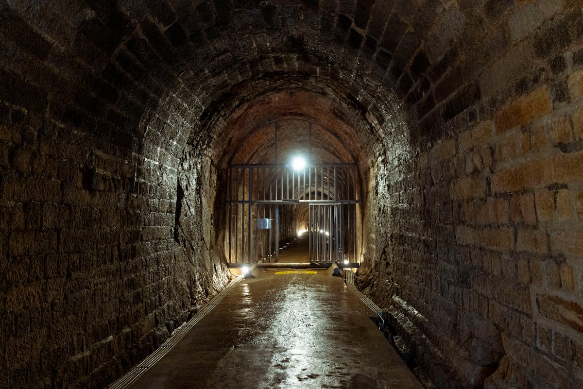 Atmospheric stone tunnel with iron gate deep underground