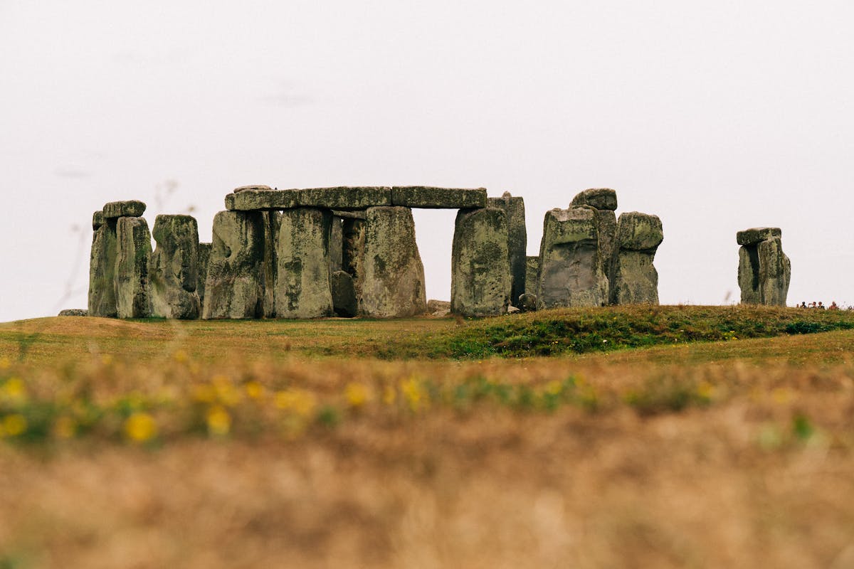 Stonehenge standing stones on grassy field under overcast sky in the UK