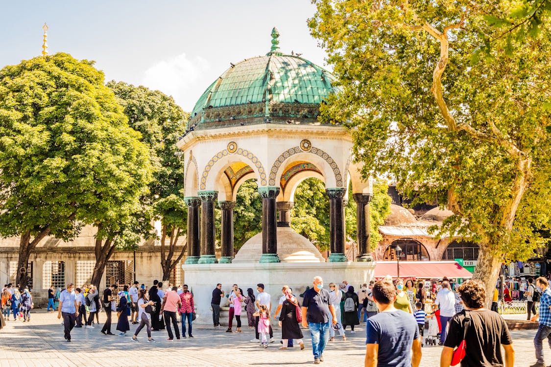 People walking past the German Fountain in Sultanahmet Square Istanbul