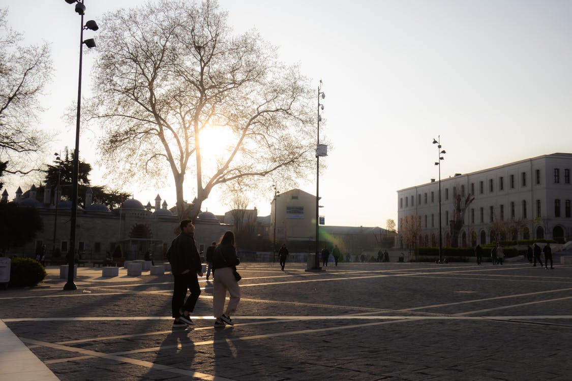 Silhouettes of people walking at sunset in Istanbul historic square