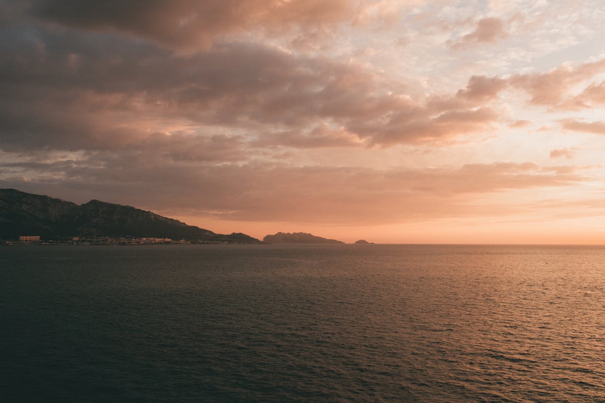 Sunset over the Mediterranean coastline in Marseille with pink and orange sky