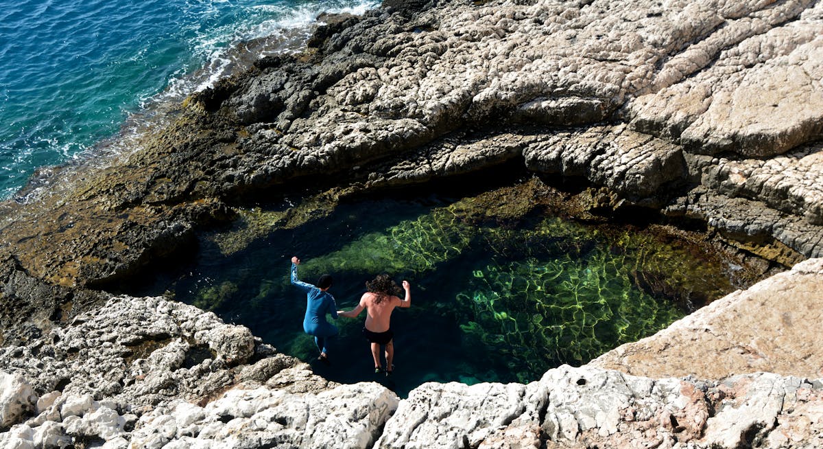 People swimming in a natural rock pool along the Turkish coast