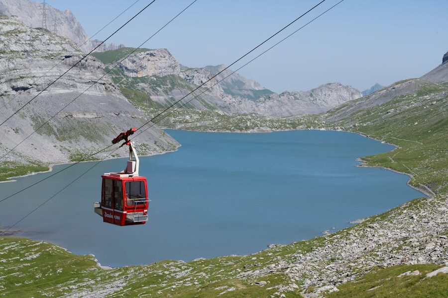 Red cable car over blue lake Swiss Alps