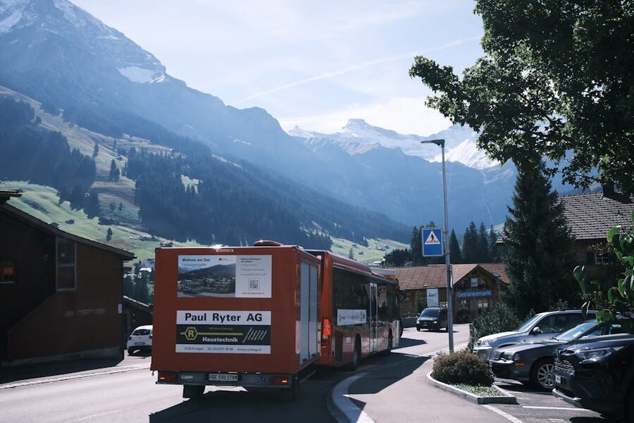 Red bus through Swiss village mountains