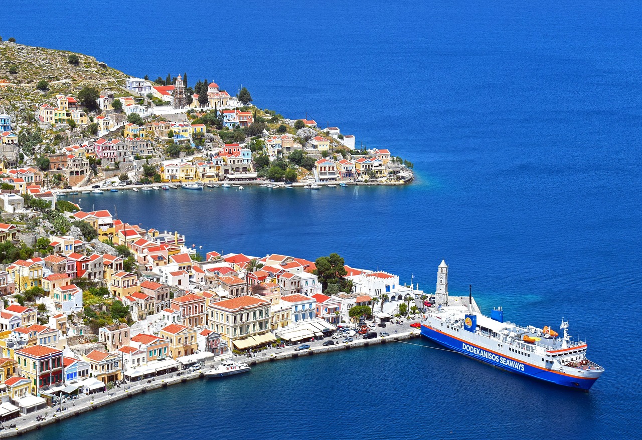 Small boat moored in colourful Symi harbour Greece