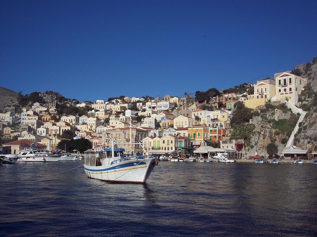 Traditional boat near colourful waterfront in Symi Greece