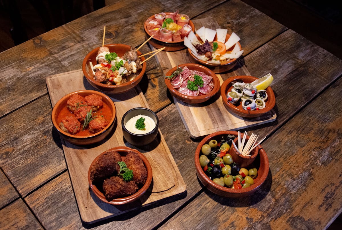 Assortment of traditional Spanish tapas served on rustic wooden boards