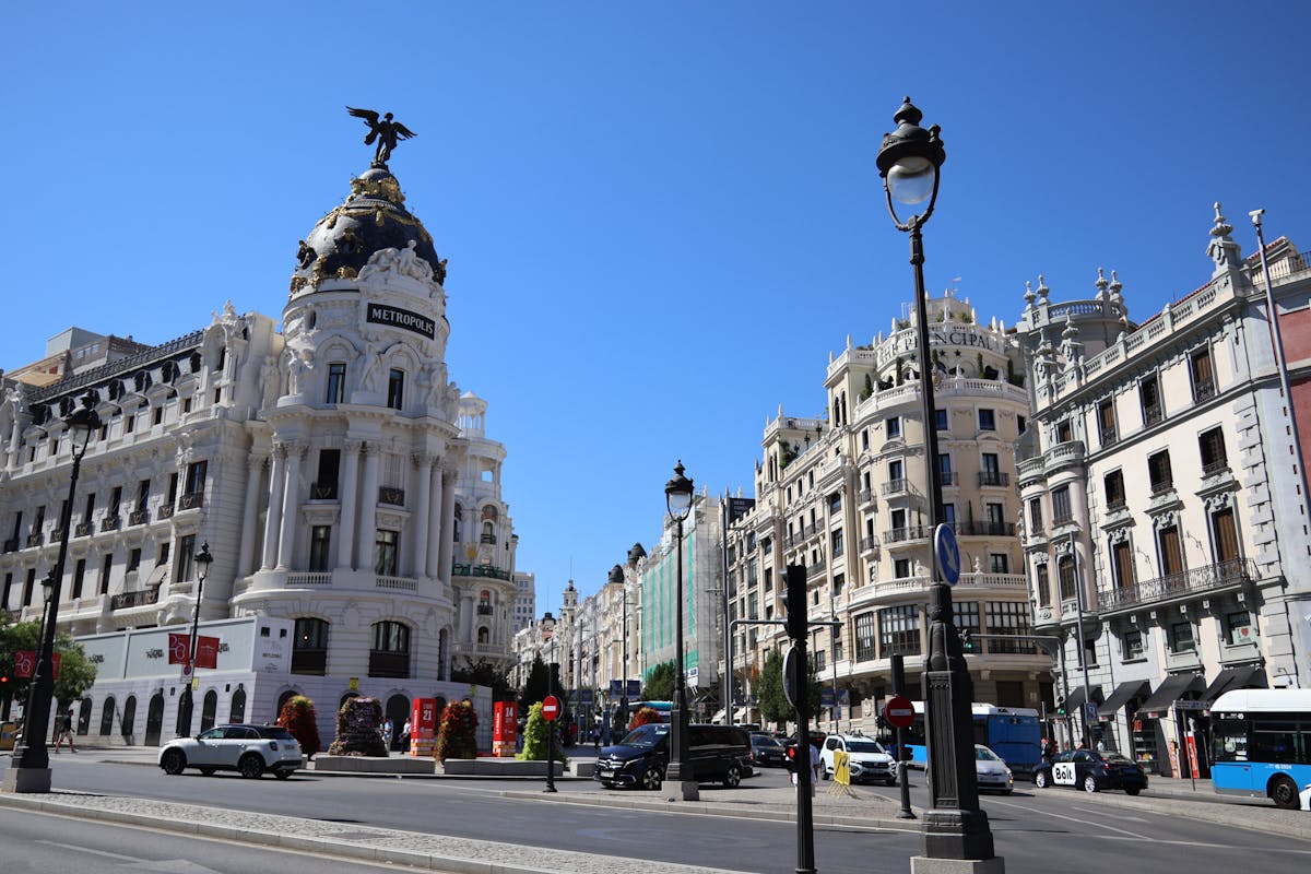 The Gran Via boulevard in Madrid lit up with sunlight and pedestrians