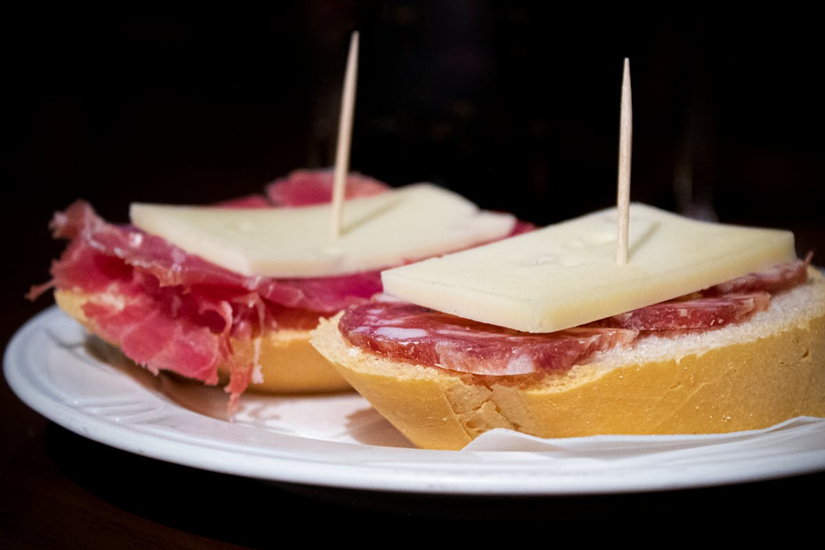 An assortment of Spanish tapas including salami and cheese on a wooden board
