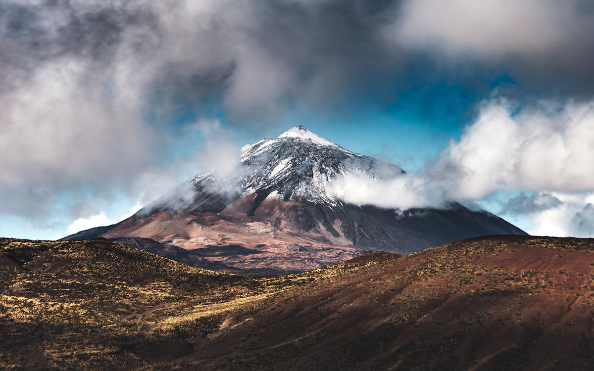 Snow-capped peak of Mount Teide with clouds drifting past in the Canary Islands Tenerife