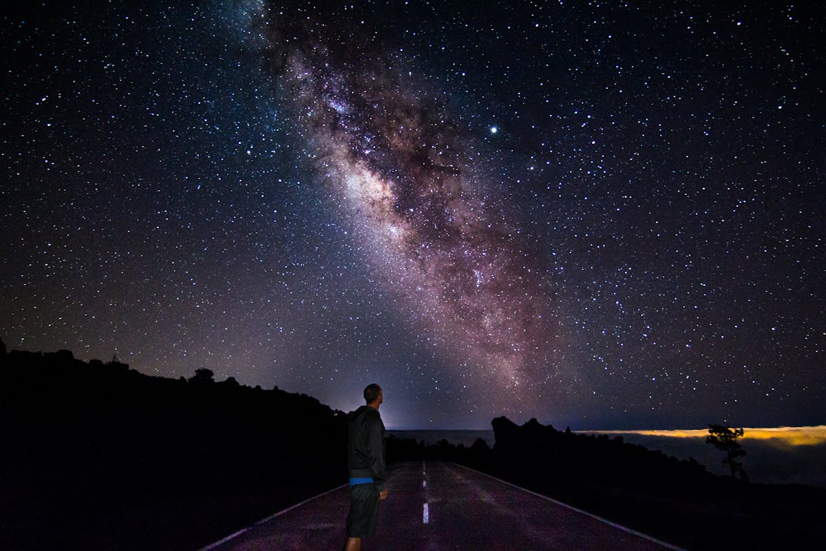 A figure gazing at the Milky Way in the star-filled sky over Mount Teide Tenerife