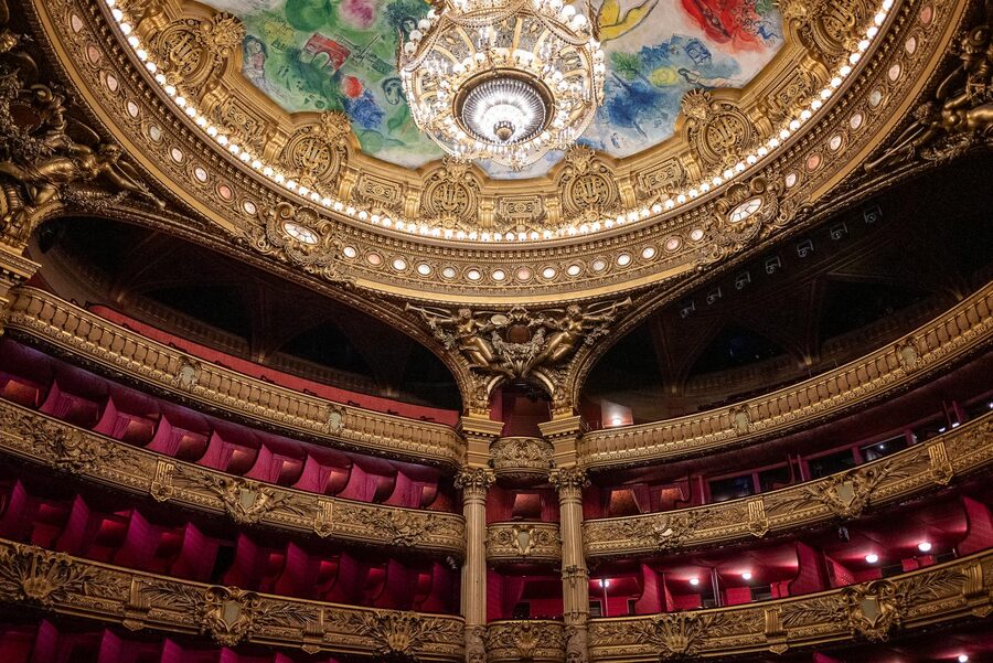 Luxurious ornate gold interior of a Parisian theater with chandelier and elaborate decorations