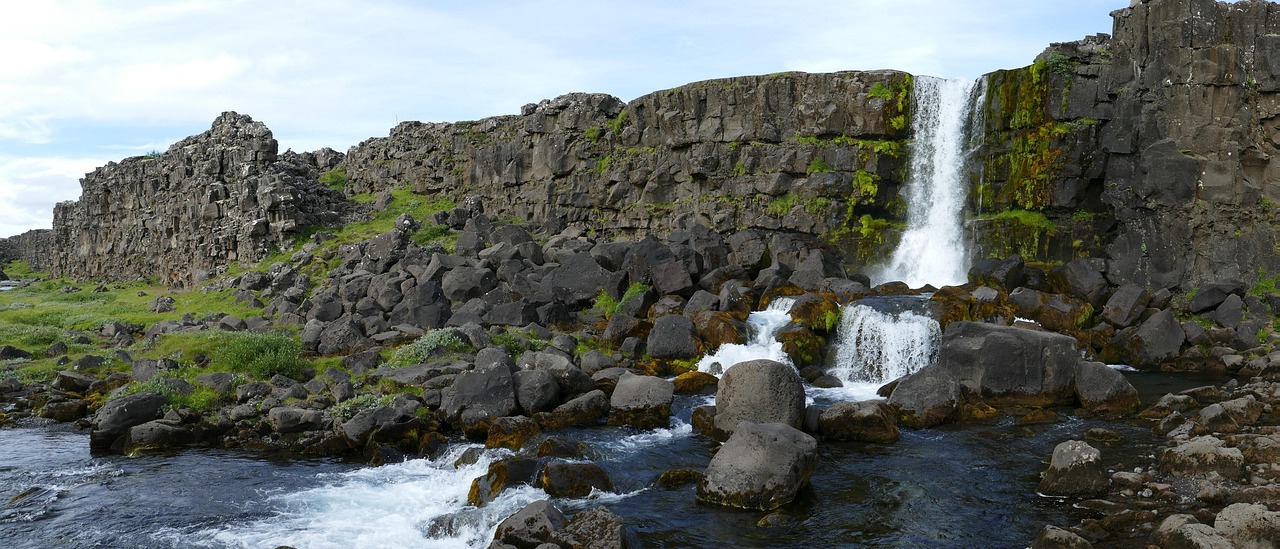 Panoramic view of Thingvellir National Park showing tectonic plate rift and waterfall in Iceland