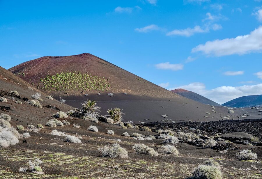 Barren volcanic terrain under blue skies in Timanfaya National Park