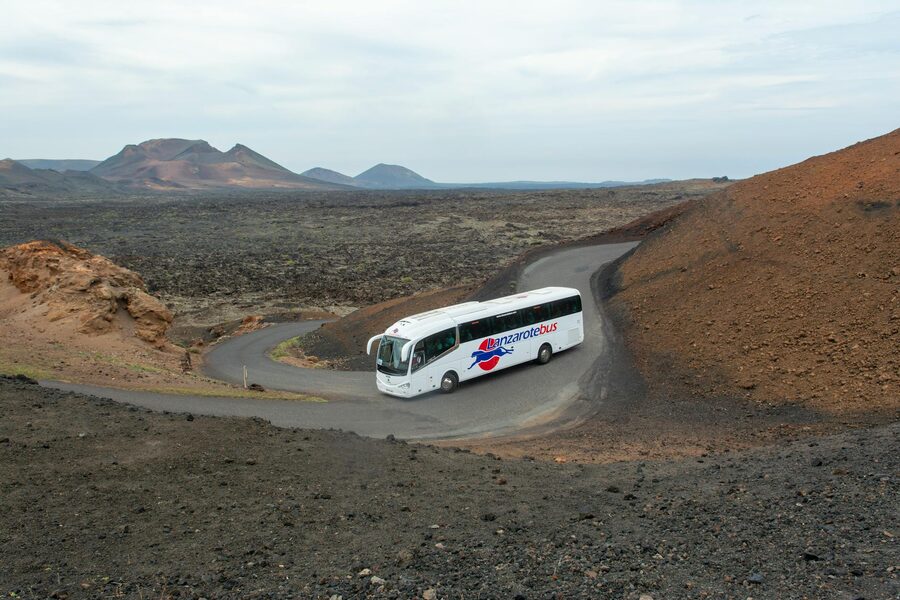 Coach bus driving through volcanic terrain in Lanzarote