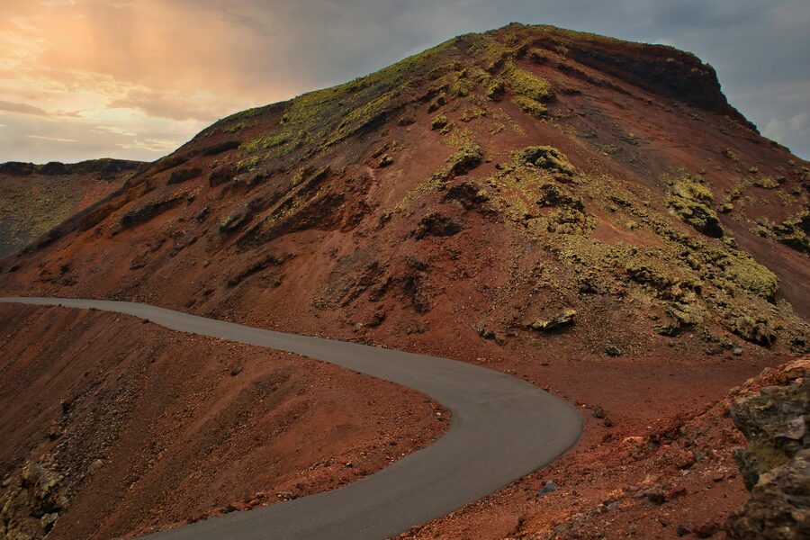 Curved road through striking volcanic landscape in Lanzarote
