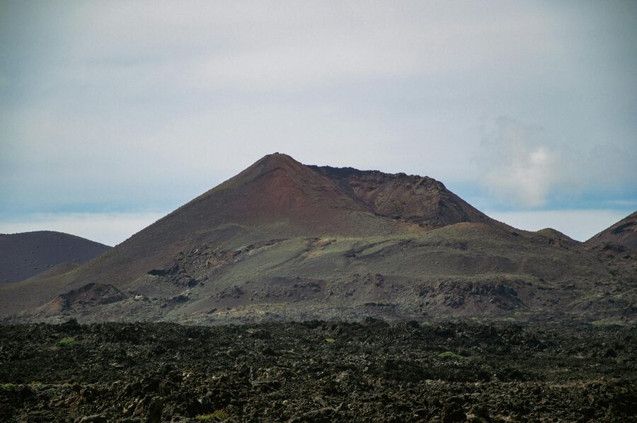 Dramatic volcanic terrain under blue sky in Timanfaya National Park