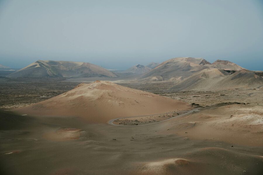 Volcanic terrain in Timanfaya National Park showing red and brown earth