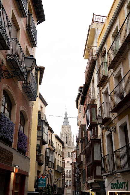 A quiet medieval alley in Toledo with stone walls and a glimpse of sky above