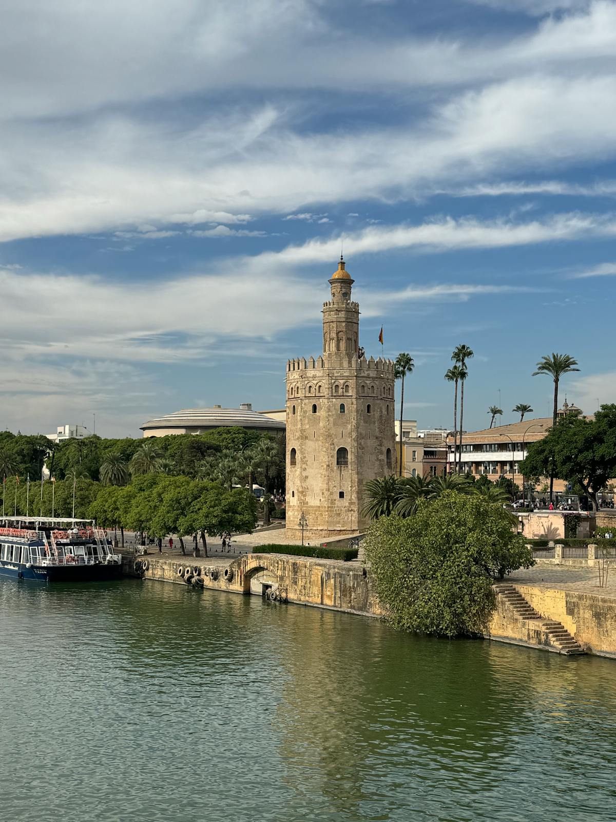 The Torre del Oro alongside the Guadalquivir River in Seville under dramatic clouds