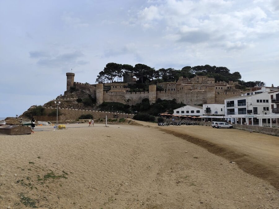 The medieval fortress of Tossa de Mar rising above the sandy beach on a bright sunny day