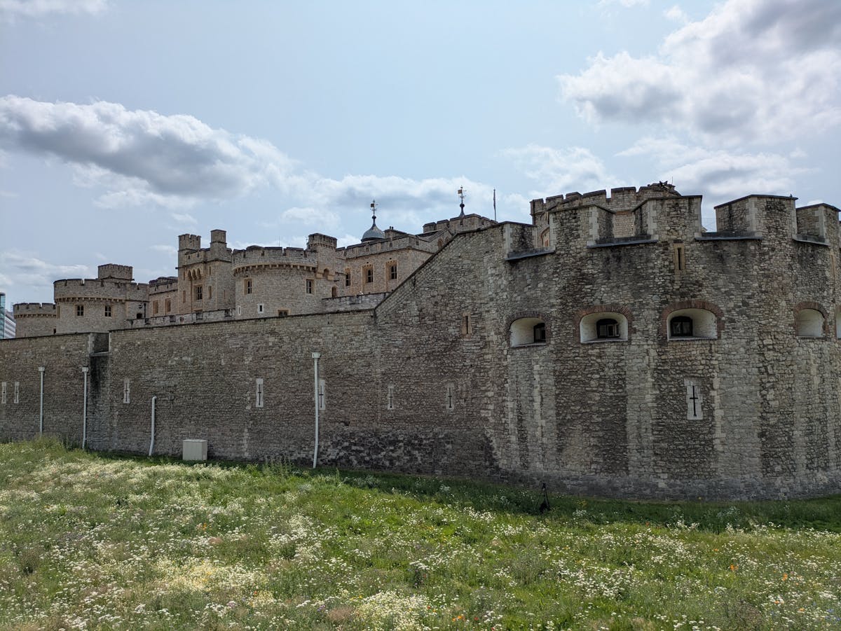 Tower of London surrounded by green lawns on an overcast London day