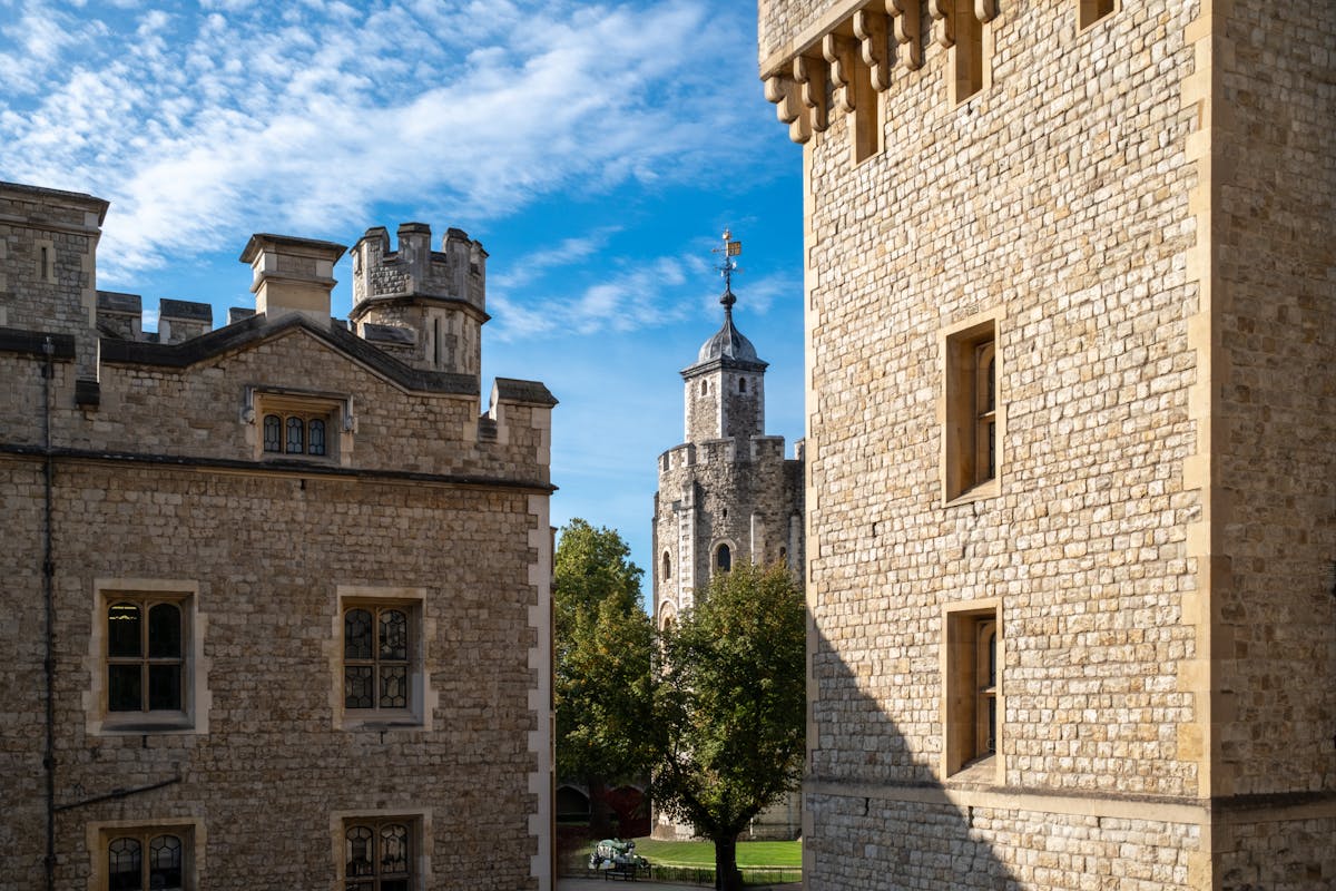 Stone towers of the Tower of London under a bright blue sky