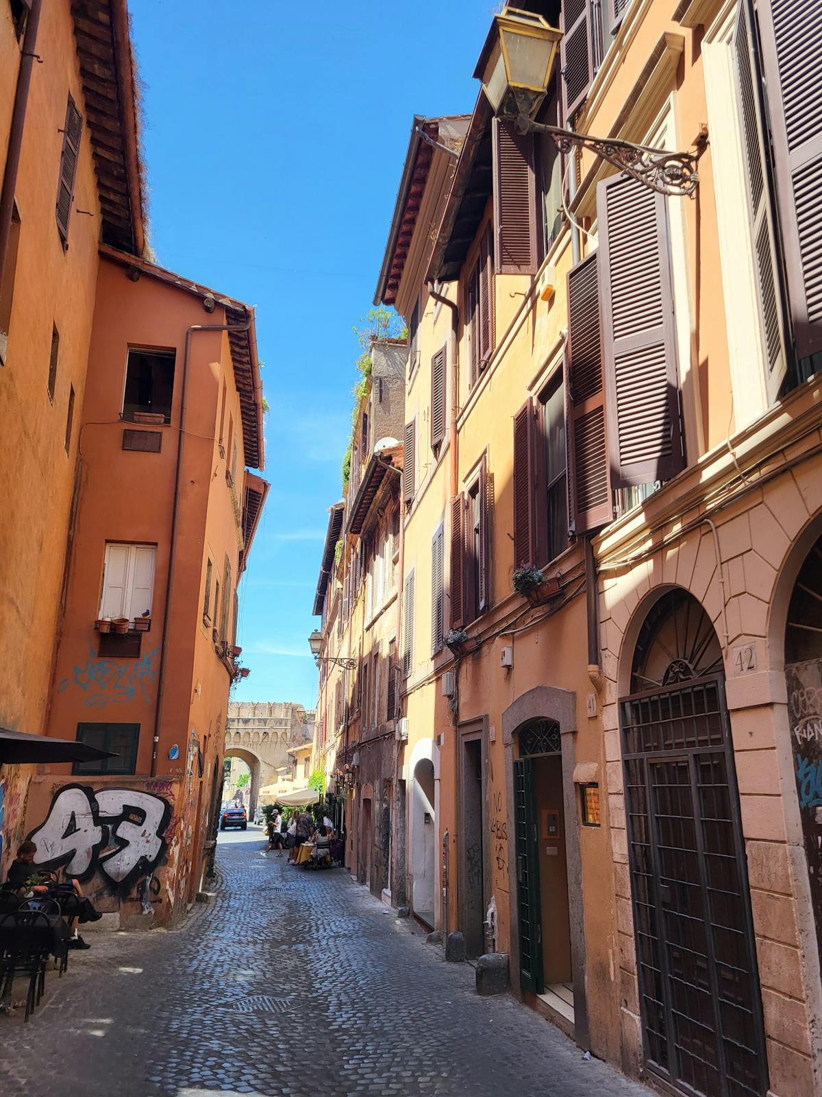 Narrow sunlit street in Trastevere Rome with colorful facades