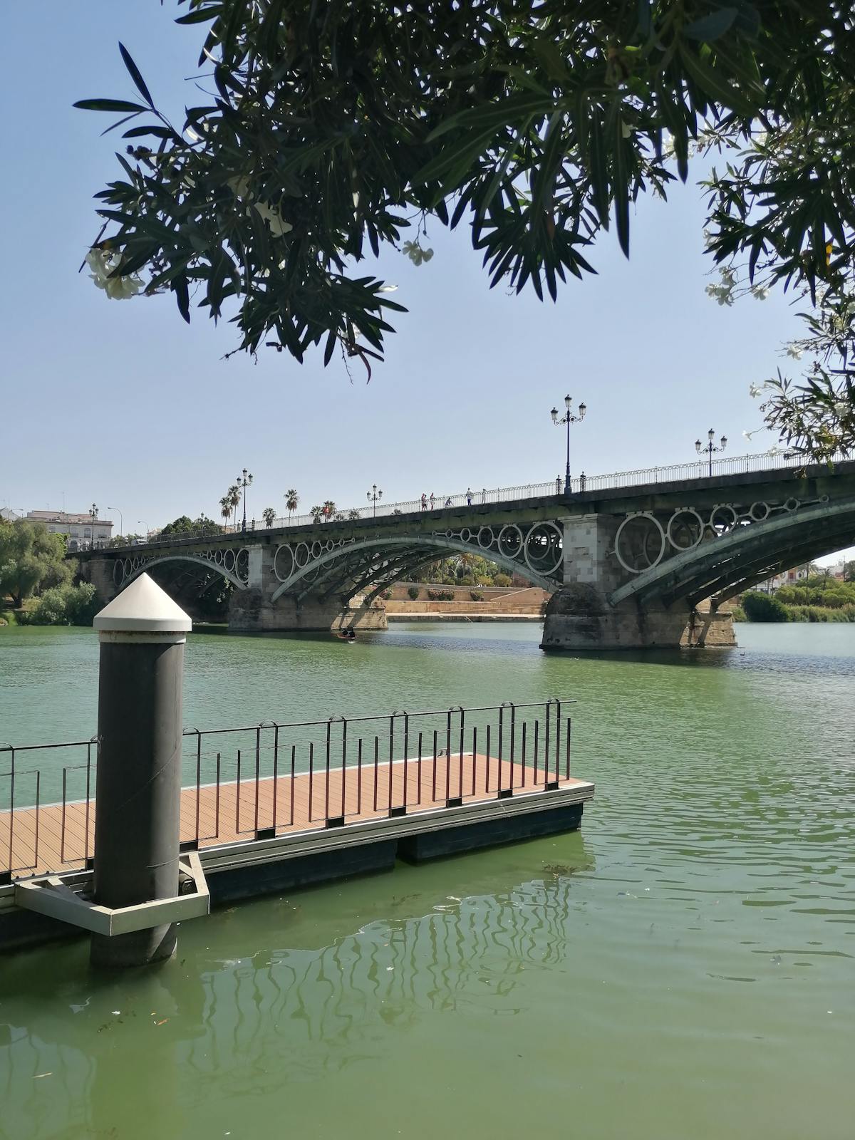 The historic Triana Bridge spanning the Guadalquivir River on a clear day in Seville