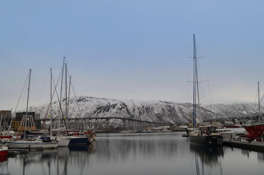 Tromso harbor with boats and snowy mountains