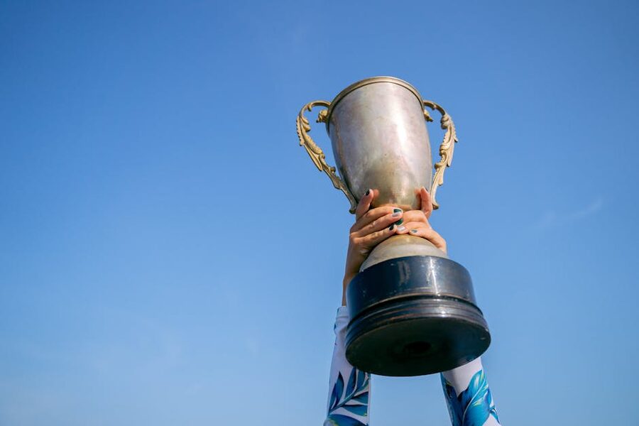 Trophy held up against blue sky symbolizing victory