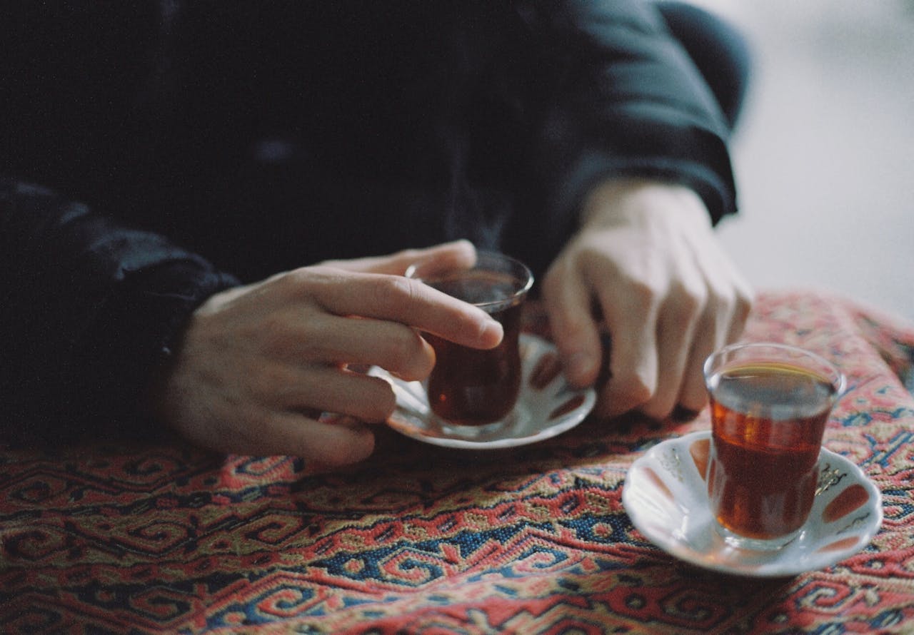 Turkish tea served in a traditional tulip-shaped glass on a patterned tablecloth