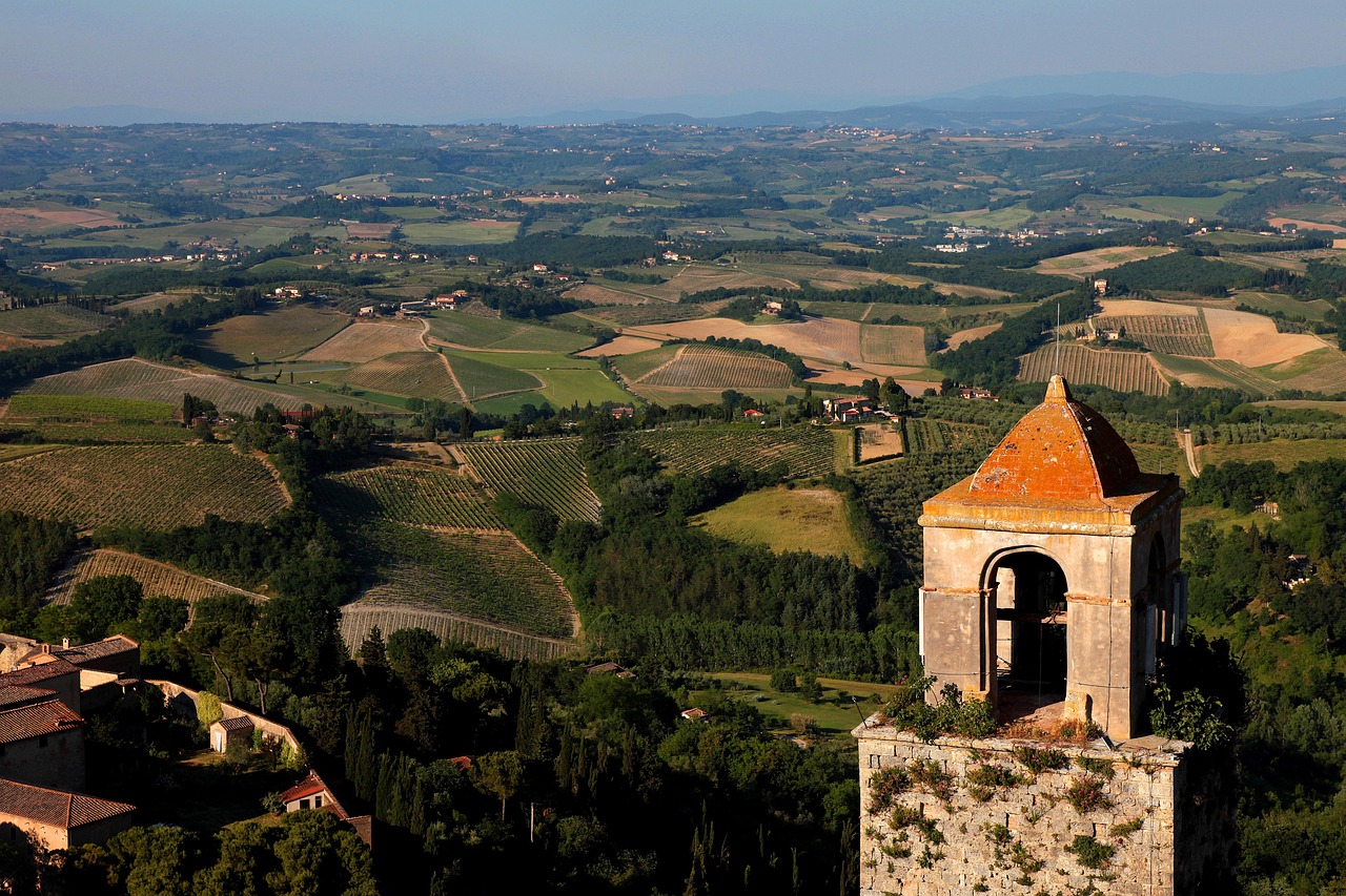 Green Tuscan landscape with San Gimignano visible on the hilltop in the distance