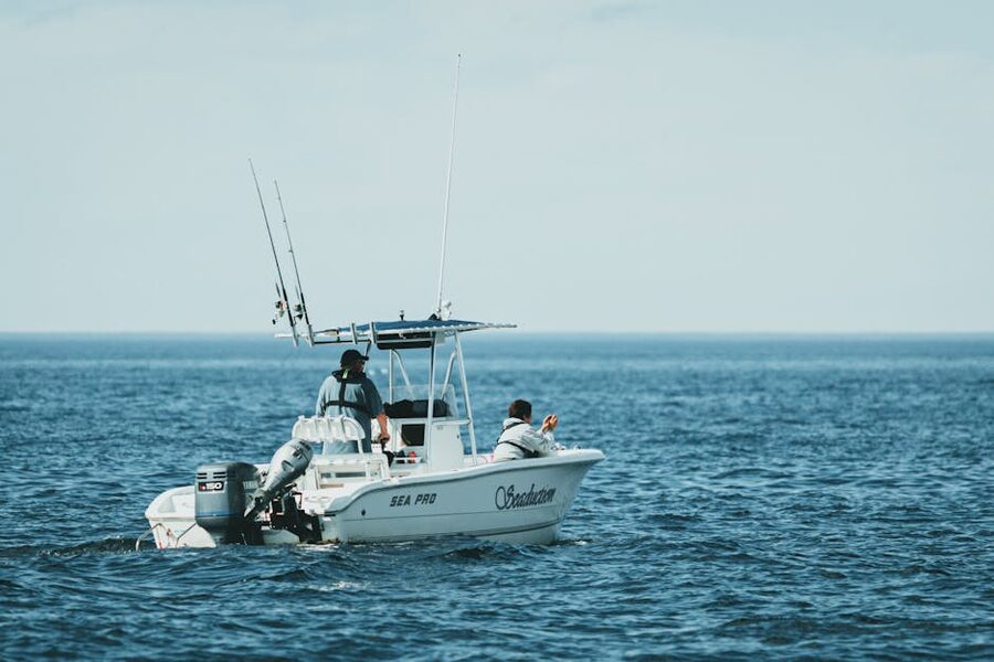 Two people fishing from a small boat on calm sea