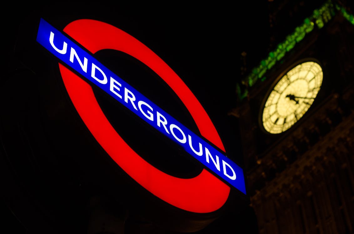 Night view of the London Underground sign with Big Ben illuminated in the background