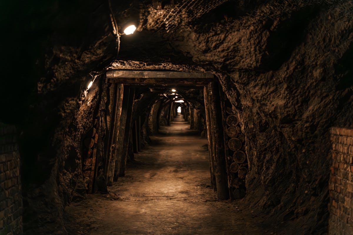 Dimly lit underground cavern tunnel showing rough stone walls