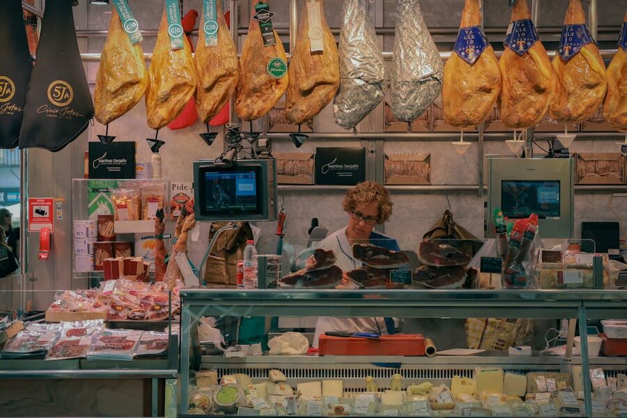 Market stall in Valencia displaying jamon and cheese