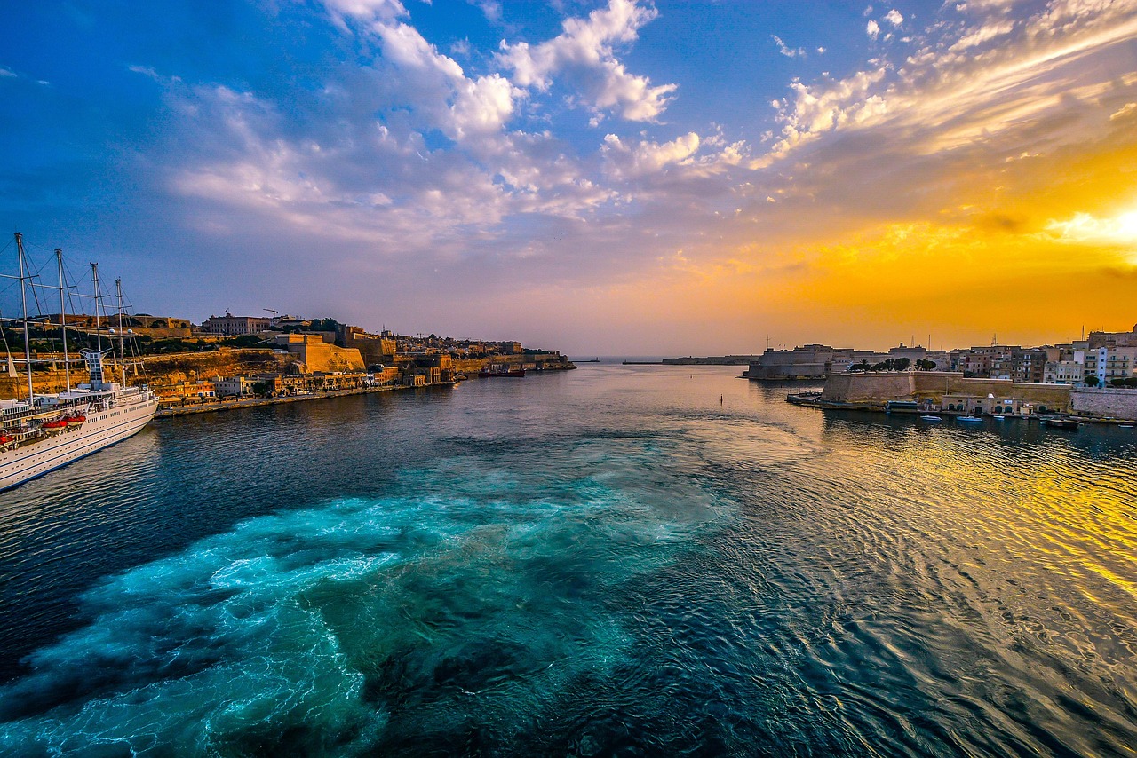 Valletta harbour with boats and fortress walls at sunset