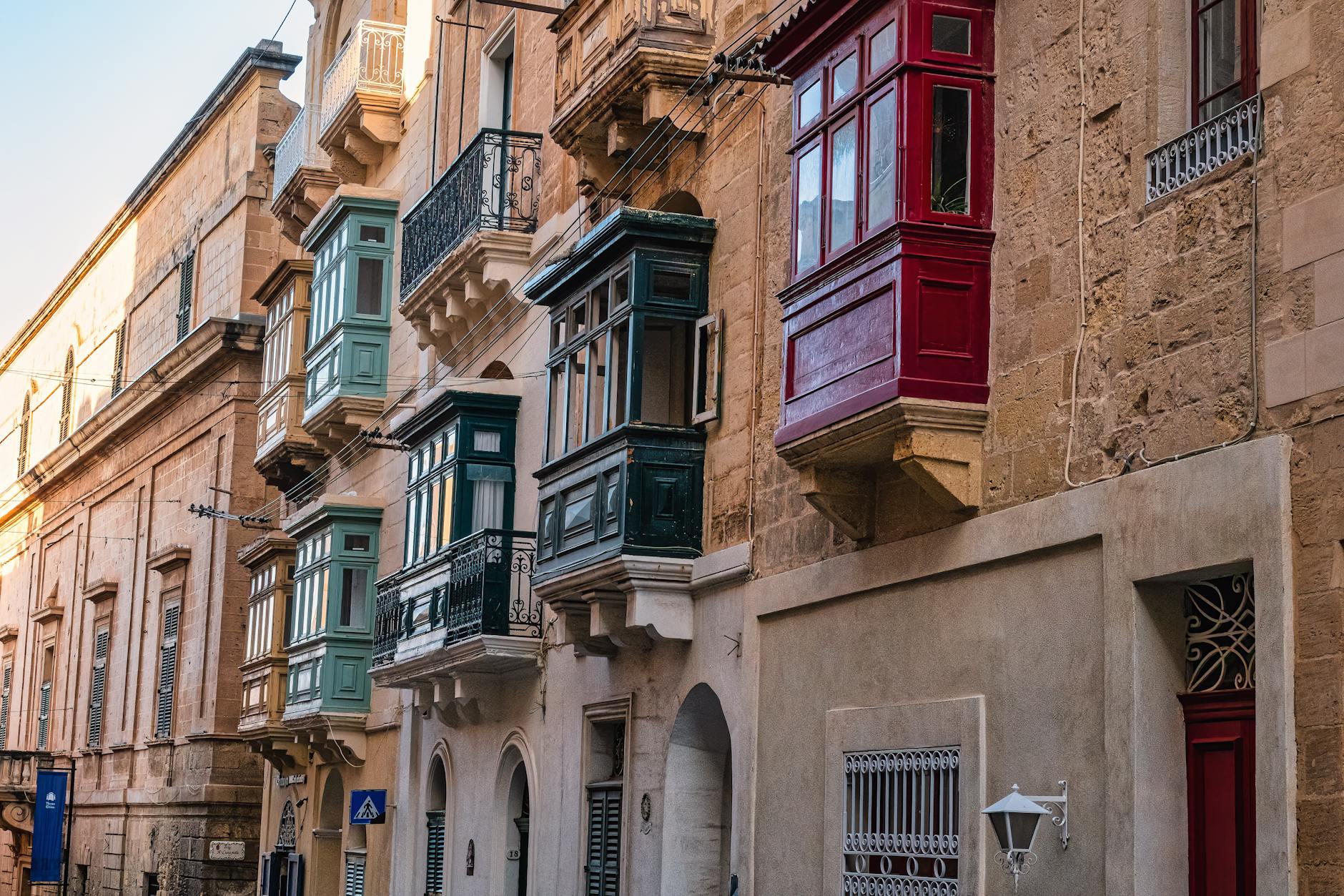 Traditional Maltese architecture with colourful balconies on limestone facade
