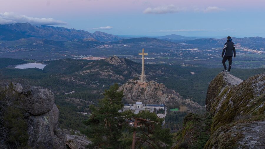 View of the Valley of the Fallen monument and cross from the Sierra de Guadarrama hills