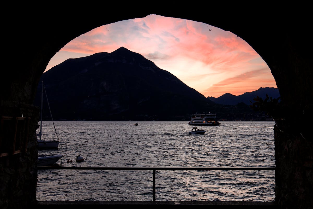 Sunset over Lake Como with boats moored in Varenna Italy