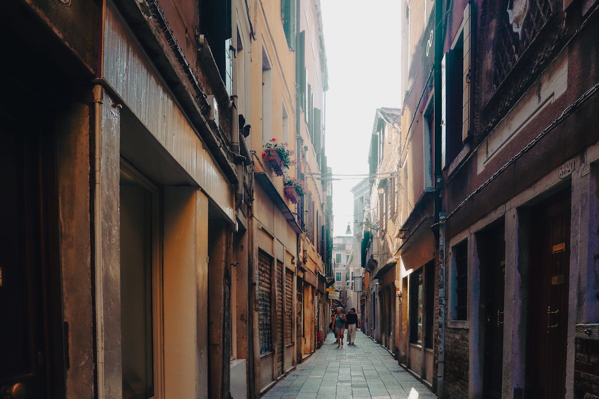 A narrow Venice alleyway bathed in warm afternoon sunlight