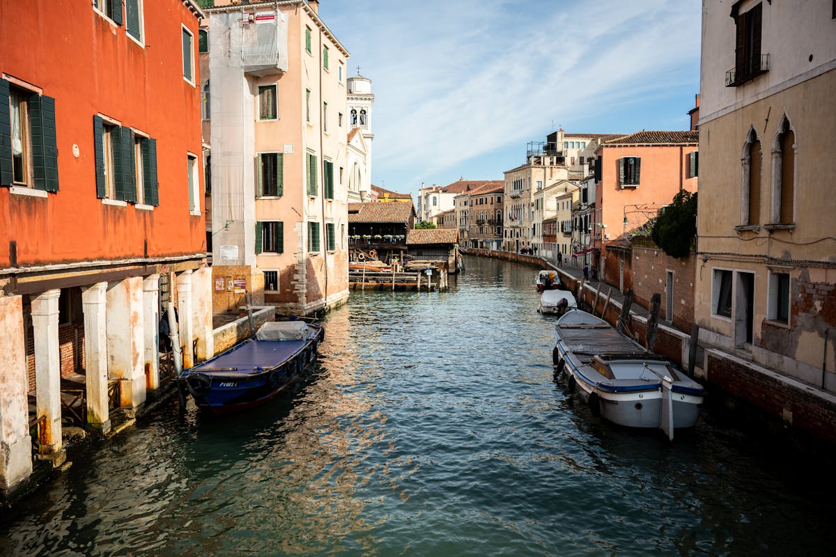 Colorful buildings lining a Venice canal with boats