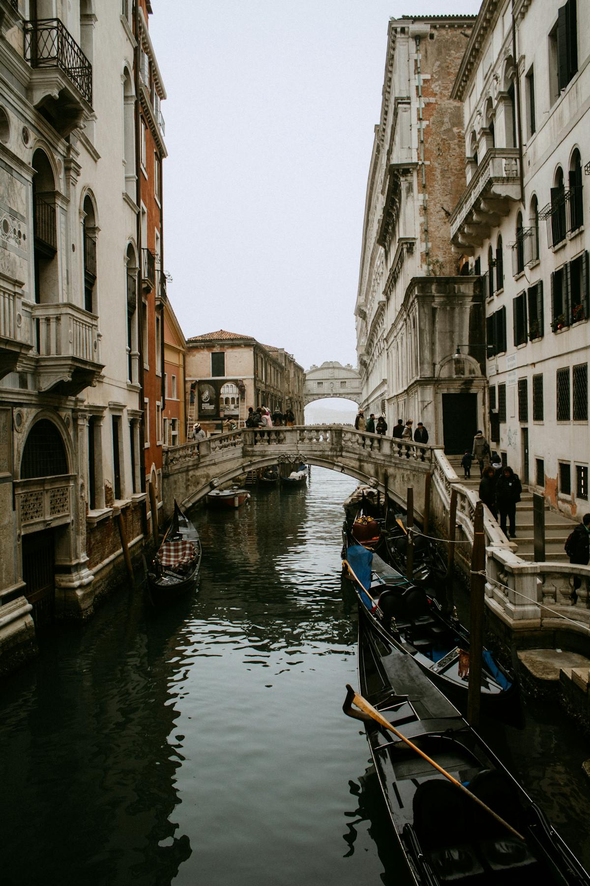 Venice canal scene with gondolas and a historic stone bridge
