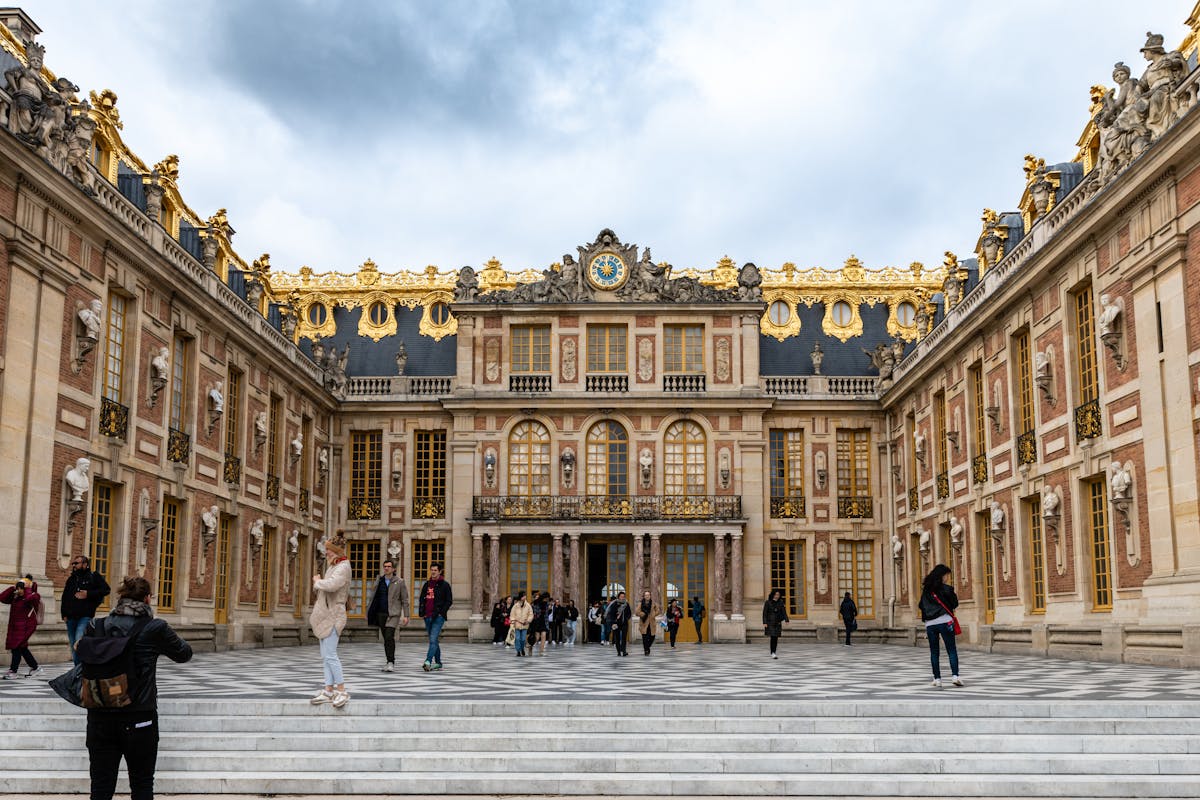 The baroque facade of the Palace of Versailles under clear skies