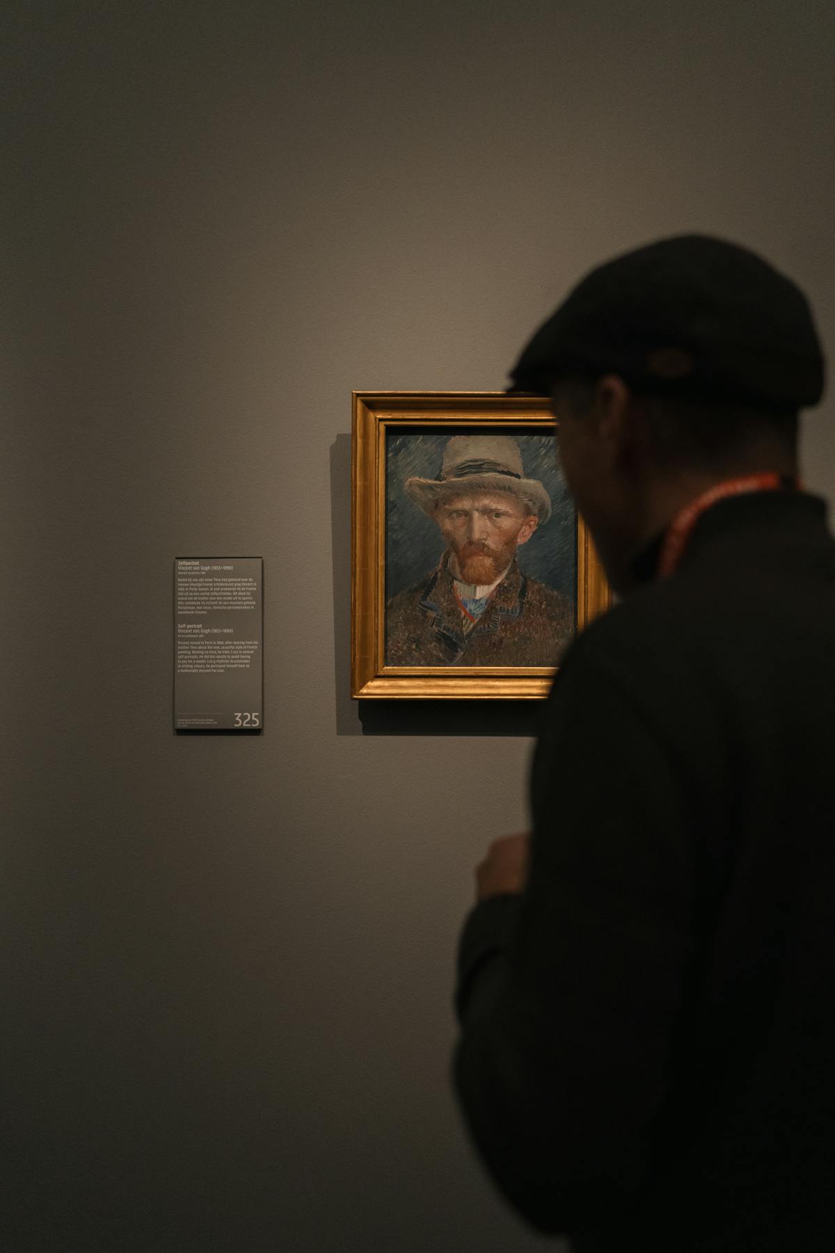 Visitor admiring a painting in a museum gallery