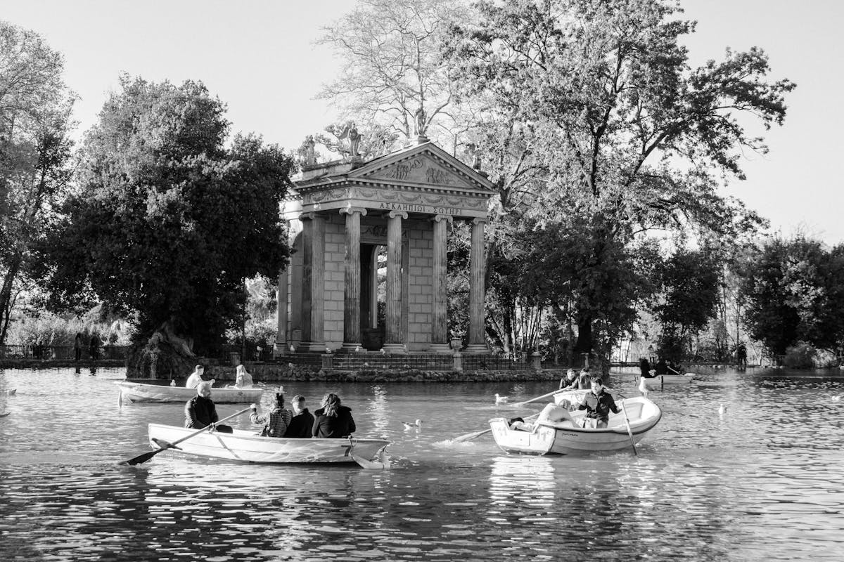 People boating on the lake near the Temple of Asclepius in the Villa Borghese gardens in Rome