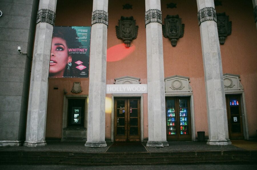 Exterior view of a vintage theater entrance with tall pillars and classical architectural details
