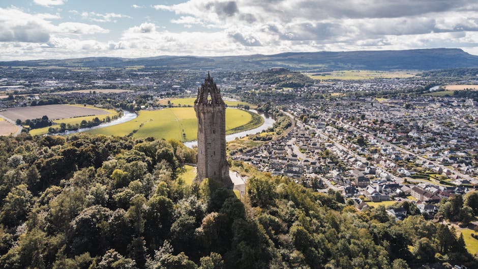Aerial view of the Wallace Monument tower surrounded by forest near Stirling Scotland